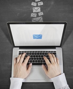 Imagen de computador con manos escribiendo email